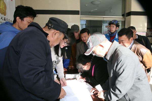 图为受益听力残疾人在受益对象确认书上签字.jpg